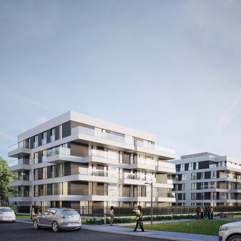 مبنى حديث بلون مائل إلى الأبيض مع شخص يمشي أمامه على طريق مرصوف. | A modern building with a whiteish hue, with a person walking in front on a paved road.