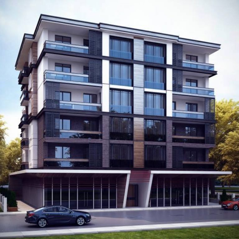 مبنى ذو واجهة زجاجية مع باب في المنتصف، محاط بالطريق المخصص للعربات ومنطقة خضراء بجانبه. | A building with a glass façade and a central door, surrounded by a paved road and a green area next to it.